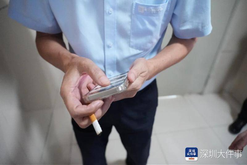 电梯门一开,正看到一吸烟男子赶紧将往垃圾桶内抖烟灰的手躲在身后